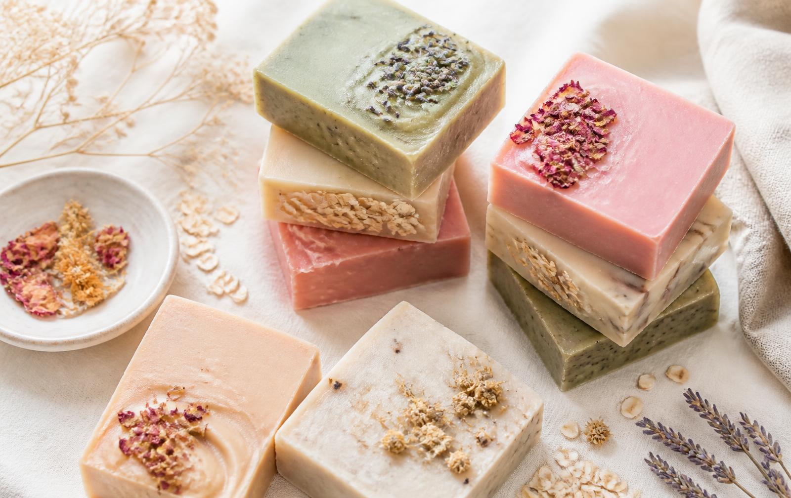 Stacked pastel handmade soap bars on cream linen